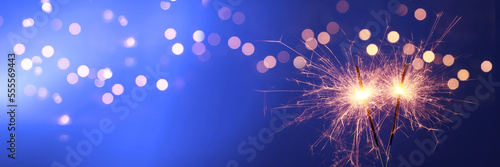 Happy New Year background with glowing sparklers.