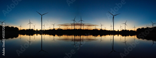 Powerful wind turbine farm for pure energy production on beautiful sunset sun setting behind wind turbine producing alternative energy for sustainable development. Renewable energy  © AU USAnakul+