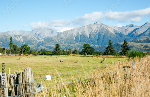 View with scree slopes on Southern Alps mountain background beyond rural plains