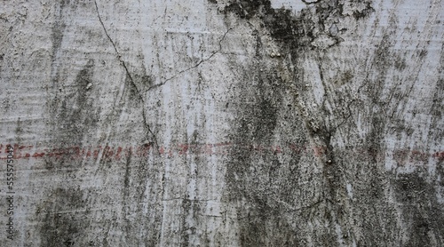 Cracks in the walls of old broken buildings. Wet with moss​ and​ nail marks on the walls. old wall background