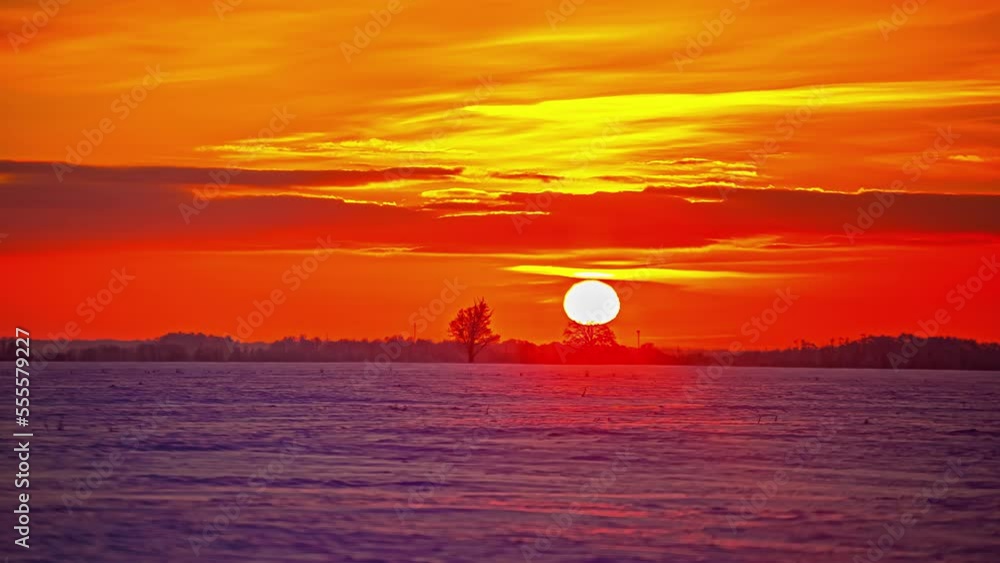 Glowing bright sunset time lapse with the sun descending beyond the horizon Glowing bright sunset time lapse with the sun descending beyond the horizon