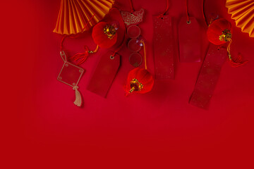 

 Chinese new year background, with festive Chinese lanterns, paper fans and traditional New Year stripes posters for wishes on bright red background copy space
