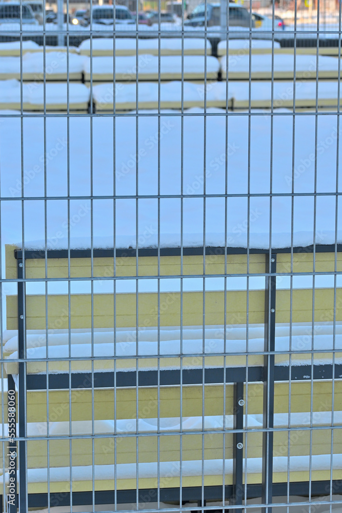 Obraz premium Metal fencing of a snow-covered court on a winter day