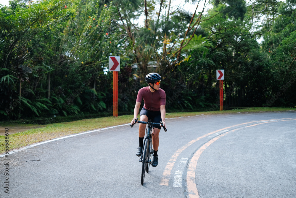 Obraz premium A young female cyclist riding her gravel bike in the mountains.