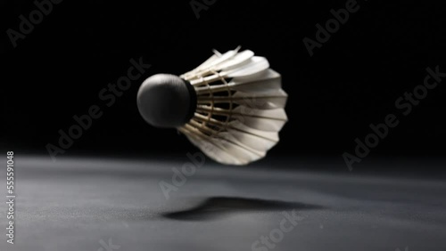 Slow motion of a Shuttlecock falling on a black background. Black background.