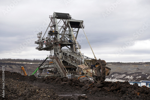 Bucket-wheel excavator during excavation at the surface mine. Huge excavator on open pit mine. 