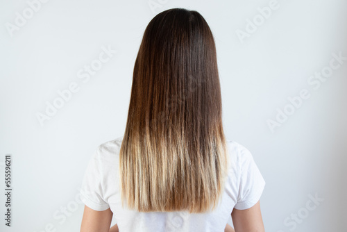 Brown long female hair after alignment with keratin on a white background, hair care