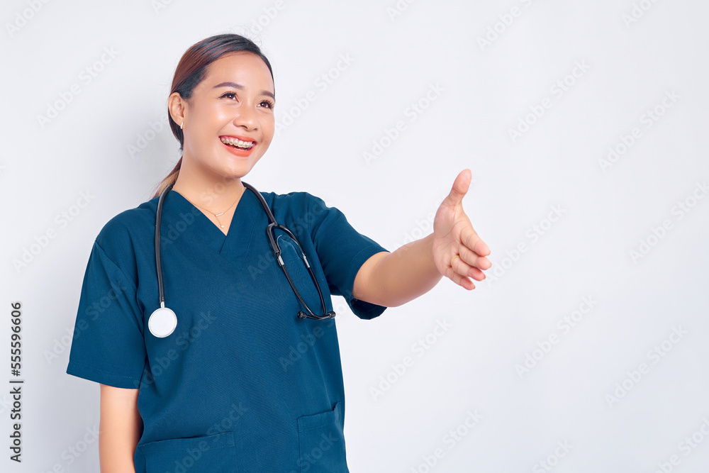 Smiling Asian woman nurse wearing blue uniform with a stethoscope extends her hand for a handshake, greeting a patient isolated on white background. Healthcare medicine concept Smiling Asian woman nurse wearing blue uniform with a stethoscope extends her hand for a handshake, greeting a patient isolated on white background. Healthcare medicine concept