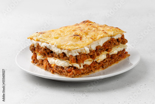 Portion of Homemade Italian lasagna. Delicious Lasagne with bolognese meat sauce on white plate. Hot Tasty Lasagna with Cheese for Menu, recipe.