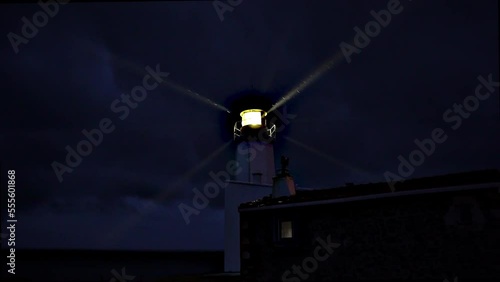 Lighthouse burning at dusk. Lighthouse light in rainy weather. Rotating lighthouse.