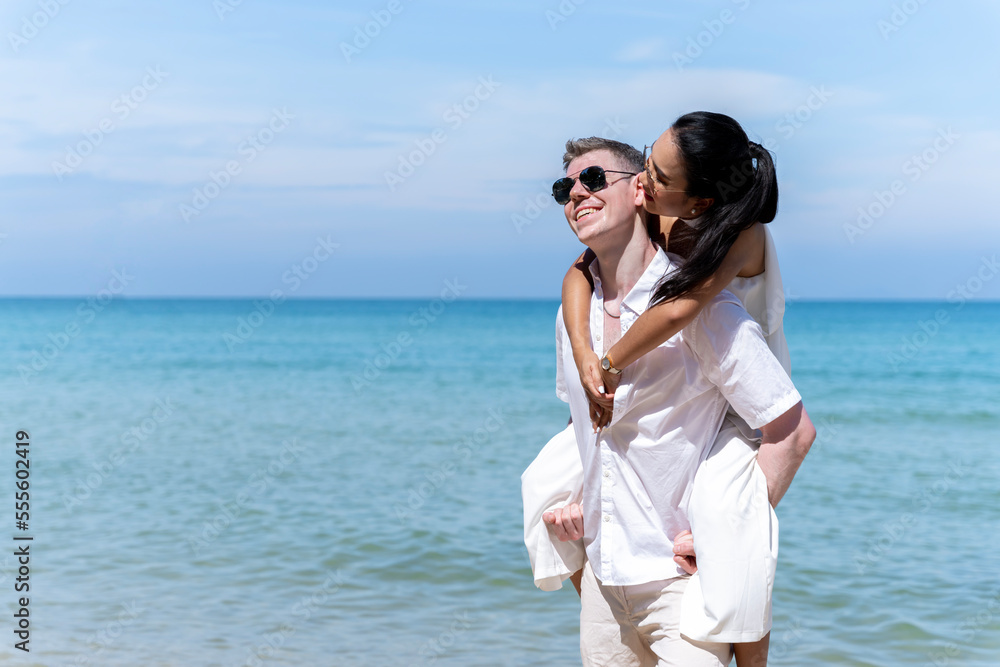 A couple of men and women of different nationalities go to the beach and walk happily on the beach together. on summer vacation A couple of men and women of different nationalities go to the beach and walk happily on the beach together. on summer vacation