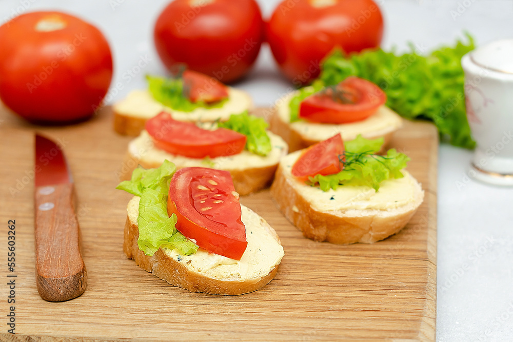 Bruschetta sandwich bread toast with soft white cheese ricotta,fresh tomatoes,basil greenery on a wooden cutting board.Tasty healthy vegetarian food,Italian cuisine appetizer. top view flat lay Bruschetta sandwich bread toast with soft white cheese ricotta,fresh tomatoes,basil greenery on a wooden cutting board.Tasty healthy vegetarian food,Italian cuisine appetizer. top view flat lay