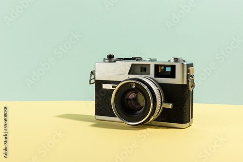 Retro camera. Old film camera on a yellow and cyan background