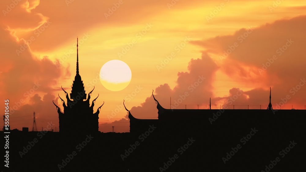 Obraz premium Silhouette image of beautiful Thai temple with sunset on dramatic peaceful summer twilight sky and clouds for holiday travel and meteorology forecast background.