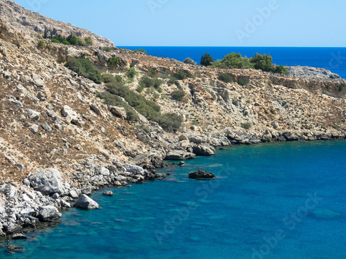 Panoramic view of the Mediterranean Sea on the rocky coast. Mountain range with clear turquoise water and blue sky. Located near Stegna, Archangelos, Rhodes, Dodecanese Islands, Greece photo