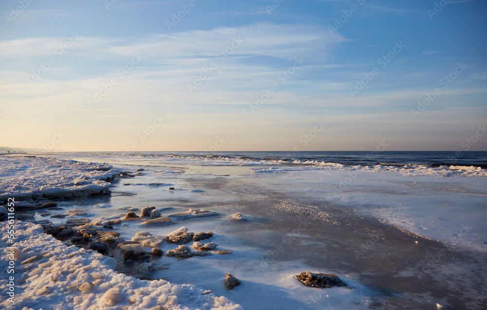 Winter landscape with icy sea coast and calm blue sky, selective focus