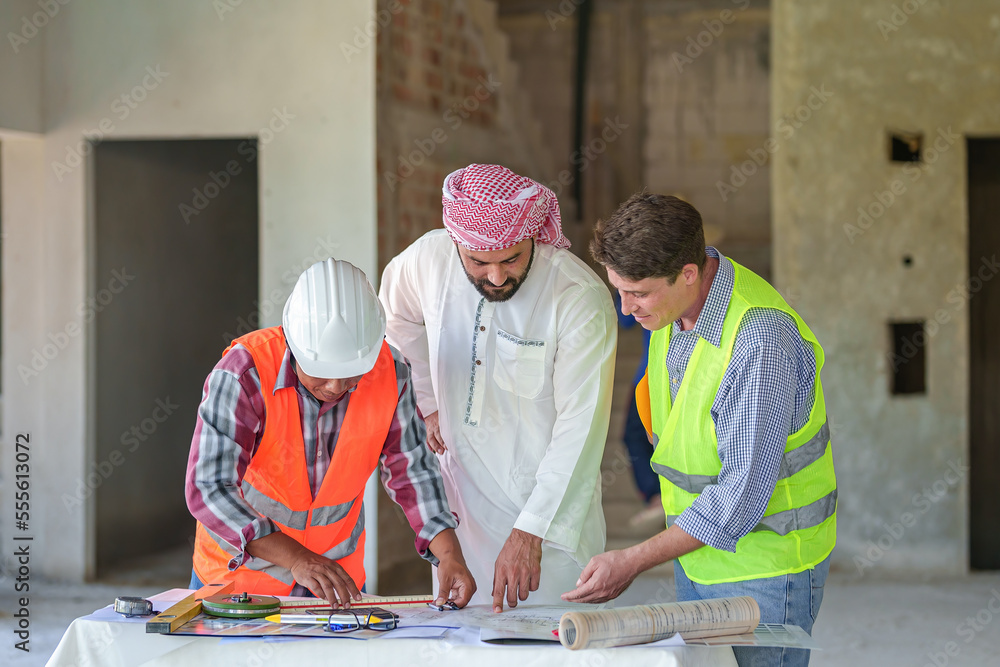 Arabic business teammates working together in office, construction engineer equipment on desk of Arab businessman. Arabic business teammates working together in office, construction engineer equipment on desk of Arab businessman.