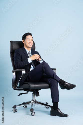 Foto Asian businessman male portrait sitting on chair and isolated on blue background