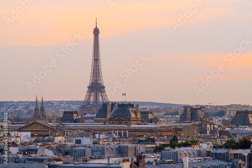 Sunset view of Eiffel Tower with Louvre museum  Notre-Dame cathedral  and Parisian rooftops. Famous landmark  icon  travel destination in Paris  France. Horizontal background  copy space  cityscape.