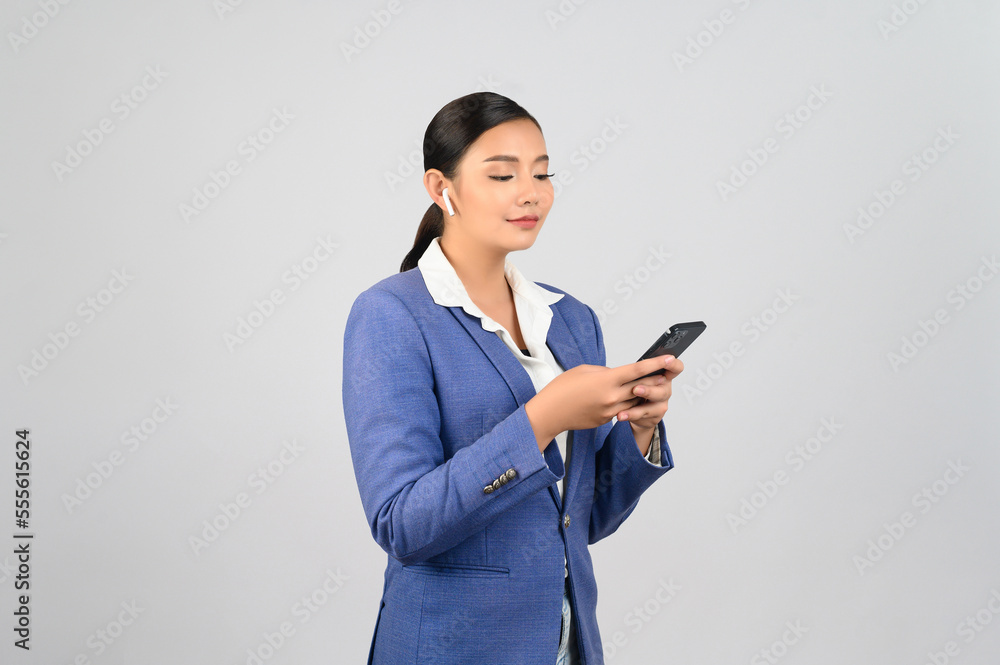 Young beautiful woman in formal clothing for officer use earphone Young beautiful woman in formal clothing for officer use earphone
