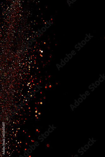 Abstract red gold shining particles on black background for design with screen