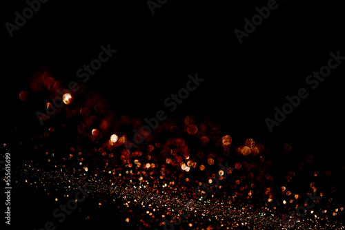 Abstract red gold shining particles on black background for design with screen