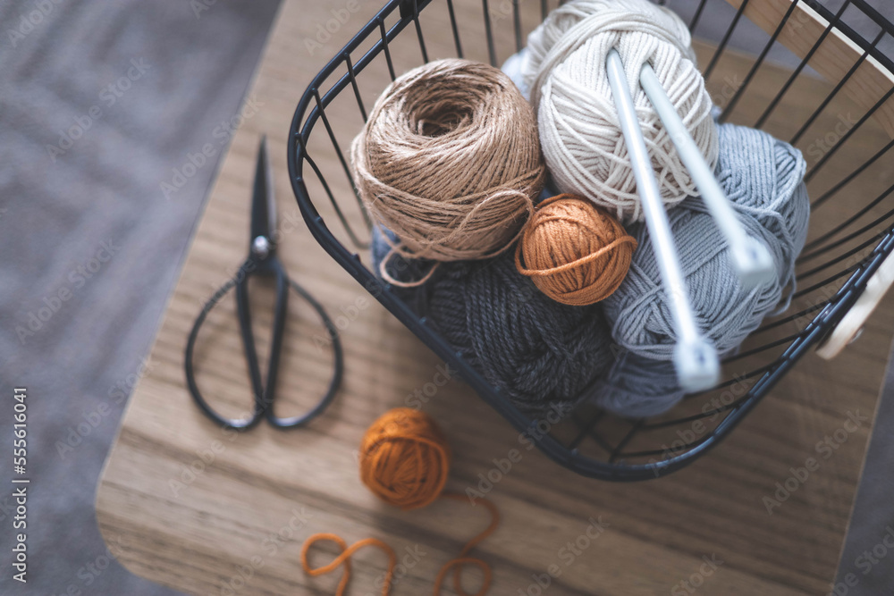 Cozy homely atmosphere. Female hobby knitting. Yarn in neutral shades in a  black iron wire basket. Stock Photo | Adobe Stock