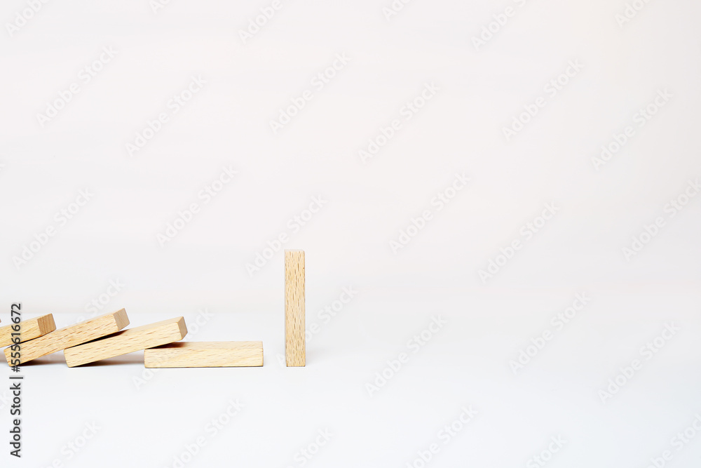 One domino stands, and other wooden dominoes fall in a row. One domino stands, and other wooden dominoes fall in a row.