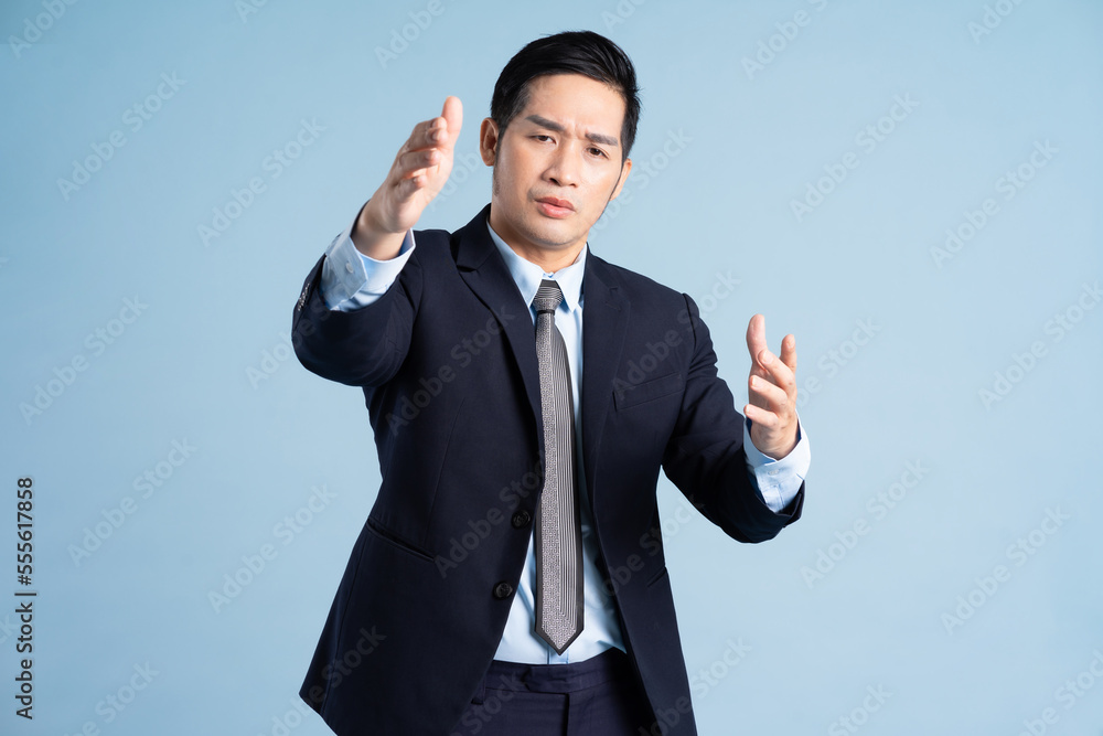 portrait of asian businessman wearing suit on blue background portrait of asian businessman wearing suit on blue background