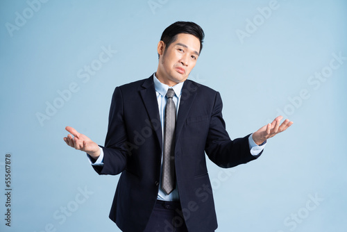 portrait of asian businessman wearing suit on blue background