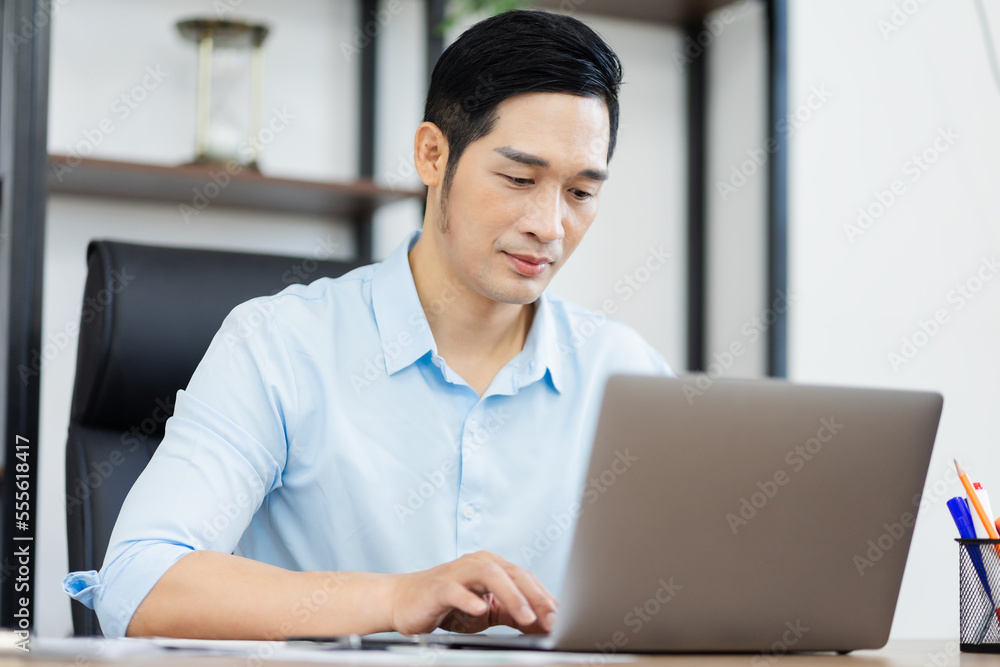 Fototapeta premium Asian businessman male portrait sitting at his desk