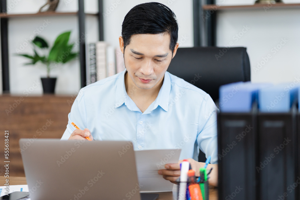 Asian businessman male portrait sitting at his desk Asian businessman male portrait sitting at his desk