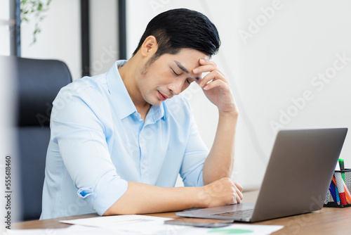 Asian businessman male portrait sitting at his desk