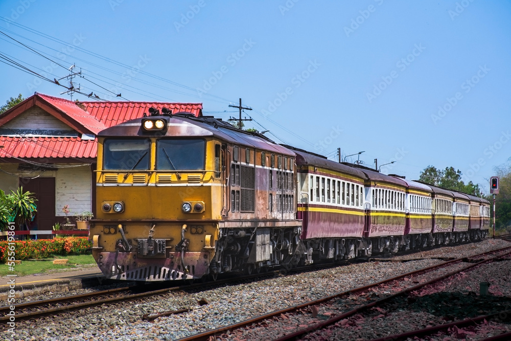 Passenger train by diesel locomotive at the railway station. (Building is public)