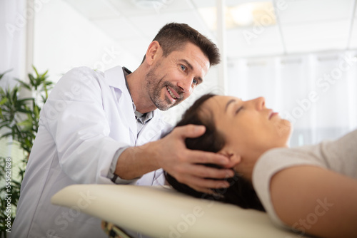 young woman getting massage seesion by a physiotherapist photo