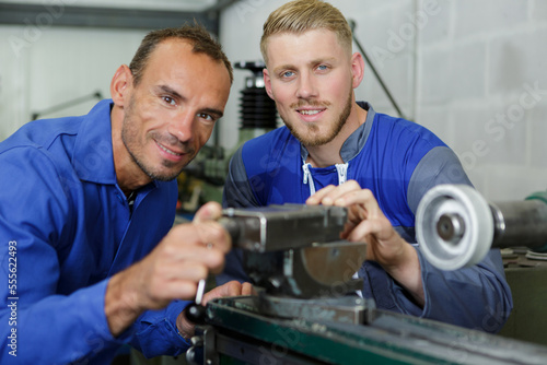 two machinists at work posing