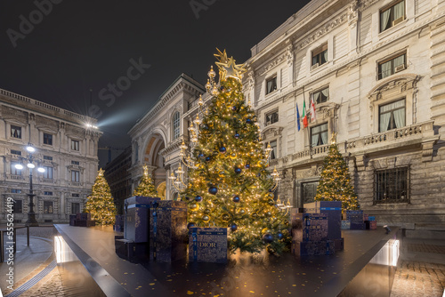 Milan, Italy - December 22, 2022: street view of a Christmas tree in Piazza alla Scala during night time, no people are visible. photo