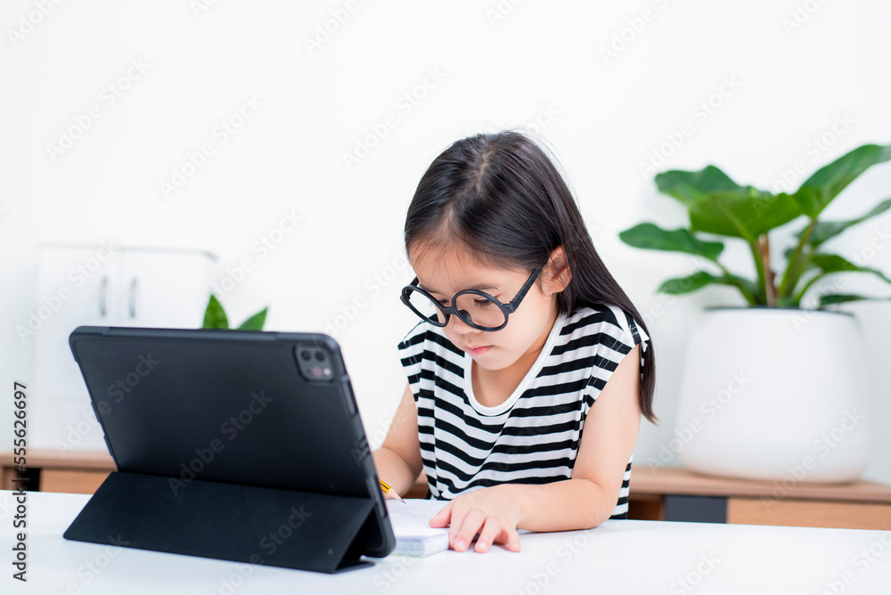 Asian child girl student wow excited on video call learning to studying online class or person learn from home school with tablet Asian child girl student wow excited on video call learning to studying online class or person learn from home school with tablet
