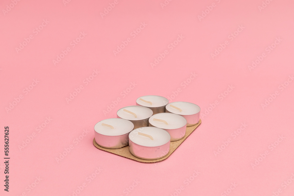 Small candles with wax on a pink background Small candles with wax on a pink background