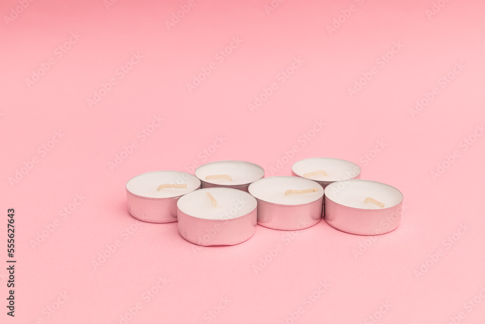 Small candles with wax on a pink background Small candles with wax on a pink background