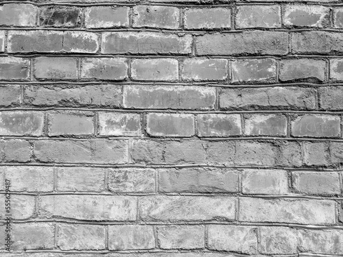 An old black and white brick wall. Historical horizontal monochrome brickwork for wallpaper and surface design.