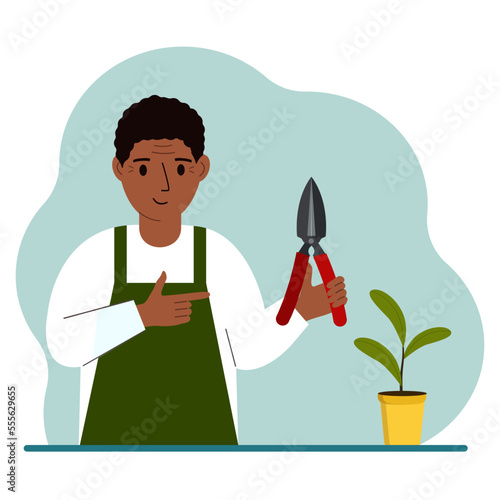 A gardener is a man in working clothes, he has a pruner in his hand.