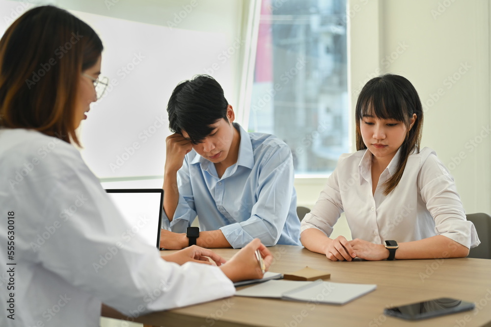 Side view female gynecologist giving advice, talking with infertile marriage about solution Side view female gynecologist giving advice, talking with infertile marriage about solution