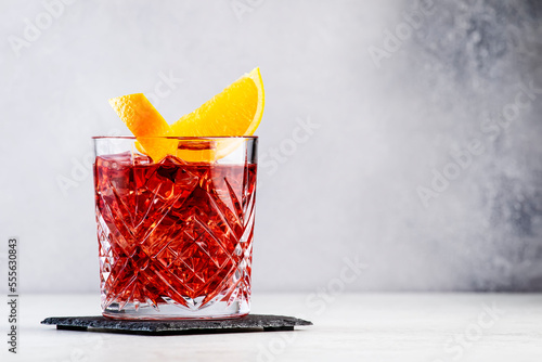 Tableau sur toile Negroni popular alcoholic cocktail with dry gin, red vermouth and red bitter, orange slice and ice cubes