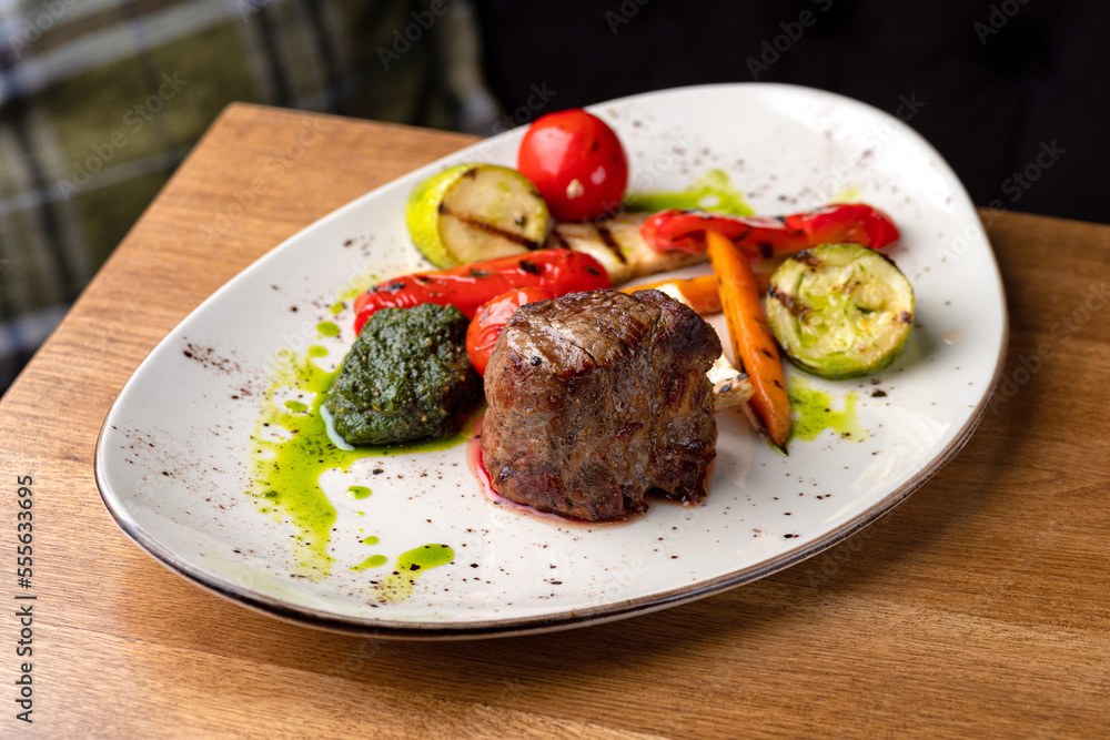 Grilled beef tenderloin steak. Filet mignon with grilled vegetables and pesto sauce