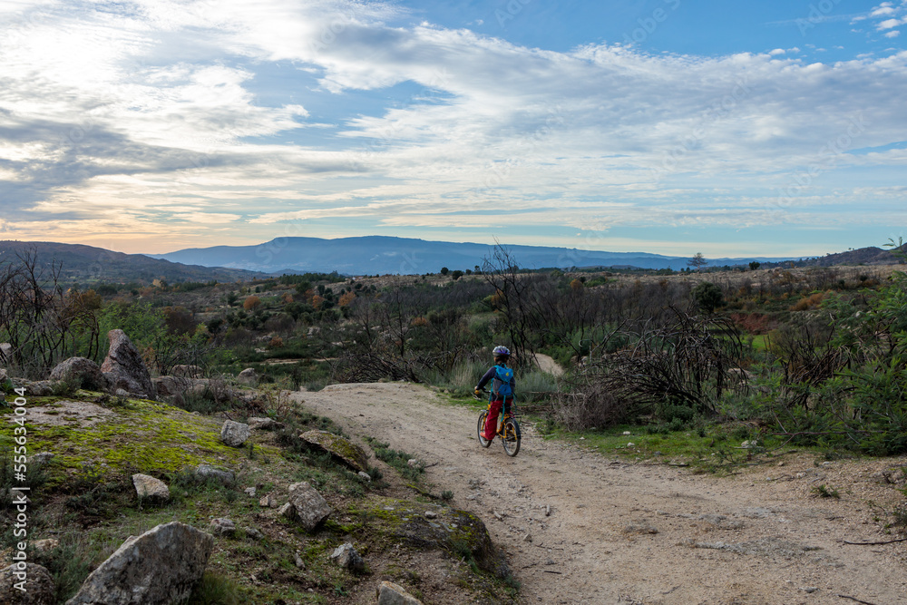 Fototapeta premium Child Cycling Through the Stunning Sierra Estrella Mountain Range in Portugal