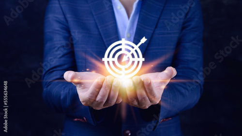 Targeting concept with businessman hand holding digital image of dartboard,Businessman holding virtual dartboard and arrow with copy space for setup business objective target concept.