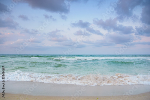 landscape at the sea in the evening. green sea water. waves washing the shore. stormy weather forecast