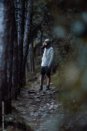 Post Apocalyptic environmental portrait with a gas mask  in a dark forest in the evening