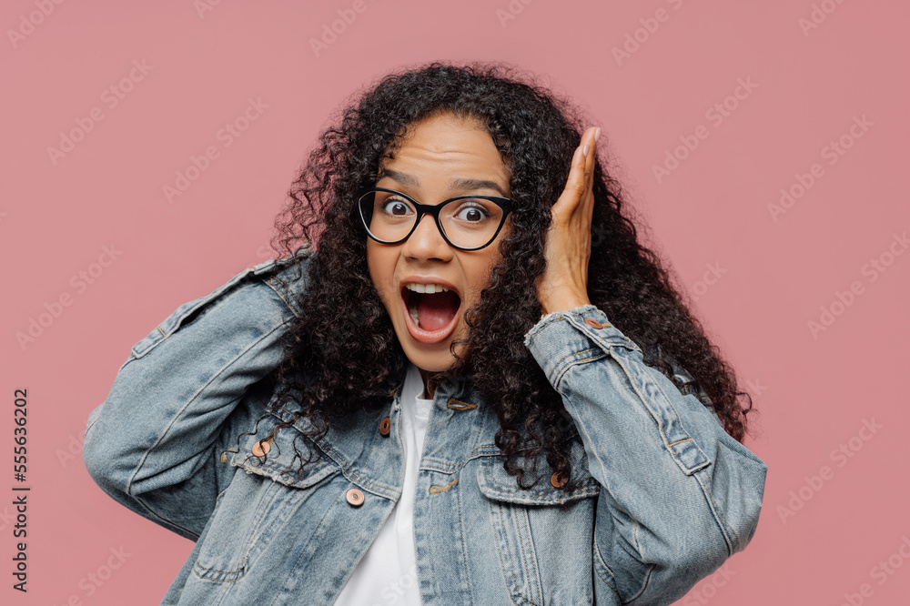 Photo of surprised Afro American woman covers ears, yells loudly